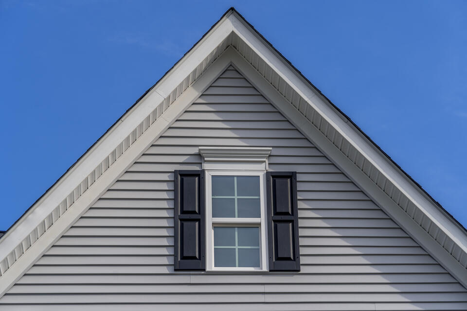 hip roof vs gable-close up gable roof on gray sided house