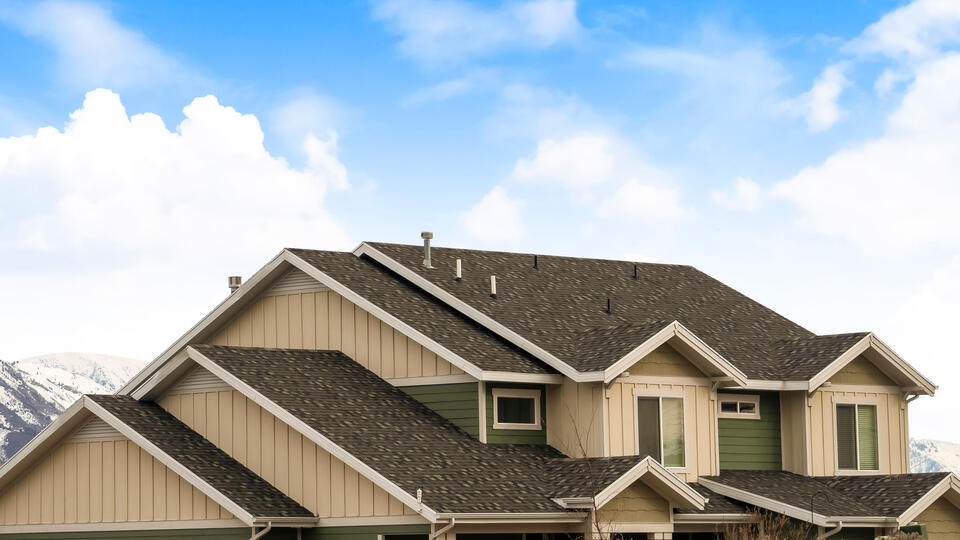 hip roof vs gable-tan and green sided house with gable roofing