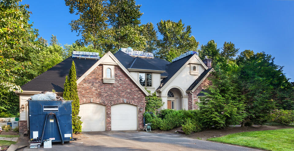 how much does a new roof cost-brick and white sided house getting shingle roof replacement