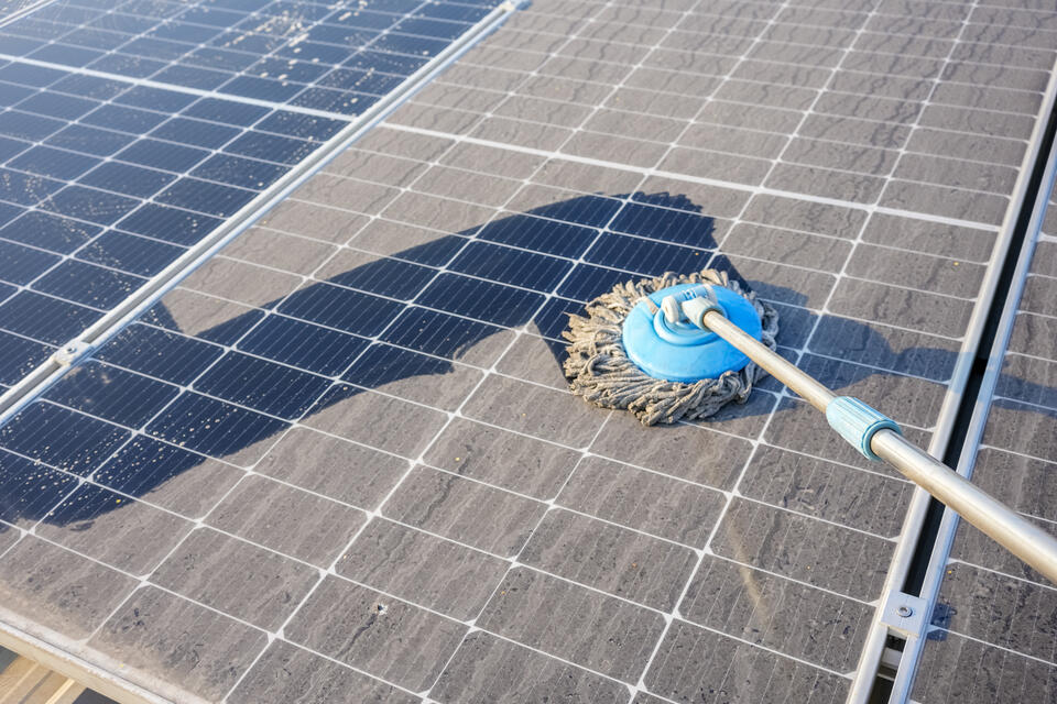 roof washing-person using a soft brush to clean roof materials